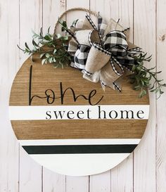 a wooden sign that says home sweet home on the side of a white wood wall