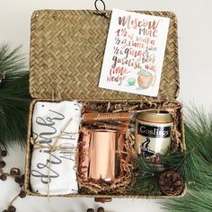 an open gift box filled with coffee, tea, and other items next to pine cones