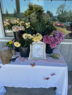 a table topped with lots of flowers next to a window