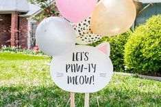 a sign that says let's party meow on it in front of some balloons