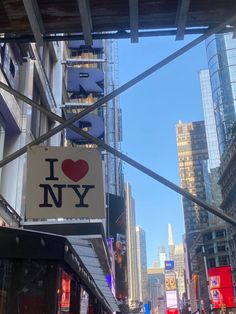 i love new york sign hanging from the side of a building on a city street