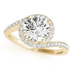 a yellow gold engagement ring with an oval cut diamond in the center and pave set shoulders