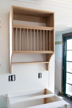 an unfinished room with wooden shelves and drawers