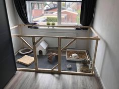 a cat house with two cats in it and a dog bed inside the window sill