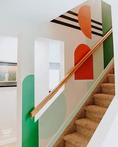 the stairs are painted with different colors and shapes in this room, along with a painting on the wall