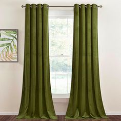 a green curtain hanging in front of a window with a painting on the wall behind it