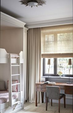 a bedroom with bunk beds, desk and chair in front of a curtained window