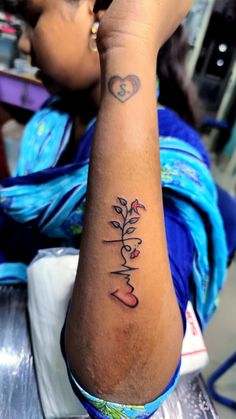 a woman's arm with the word love tattooed on her left arm and flowers in the middle