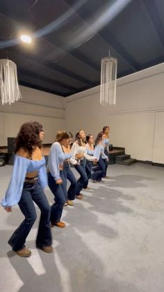 a group of women in jeans are dancing