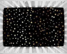 black and gold stars pattern with white stripes on the bottom, in front of a wooden background