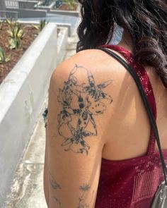 the back of a woman's shoulder with tattoos on her left arm and chest