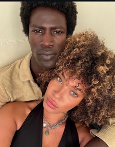 a man and woman with curly hair posing for the camera