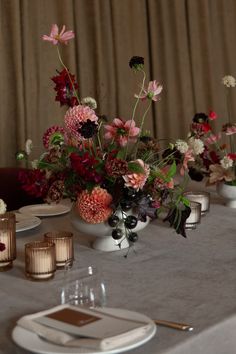 the table is set with flowers and candles