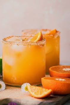 two glasses filled with orange juice and garnished with an orange slice on the rim