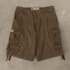 Men's Vintage Lee Cargo Shorts  + Damage: Minor Marks  + Closure: Zip  + Colour: Brown  + Size Label States: W30  + Actual measurements (inches): W30  + Measurements (Inches): Hem = 12, Rise = 12  Please note that all vintage items have been previously worn, and may show some signs of previous wear. However, any significant damage will be photographed and/or stated in the items listing. Please note that damage to the inside may not always be photographed or listed. Outdoor Short Cargo Pants, Short Length Cargo Pants For Outdoor Activities, Brown Cotton Bermuda Bottoms, Short-leg Bottoms With Pockets For Outdoor Activities, Short Leg Bottoms With Pockets For Outdoor, Outdoor Bottoms With Pockets And Short Leg, Outdoor Activity Shorts With Pockets, Brown Cotton Bermuda Shorts, Brown Bermuda Bottoms With Pockets