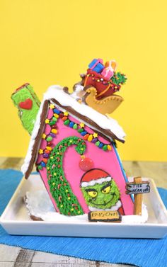 the grinch house is decorated with icing and other holiday decorations on a plate