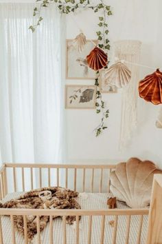 a baby's crib in a white room with hanging decorations