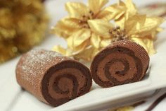 two pieces of chocolate cake on a plate with gold flowers in the background and one piece cut out