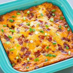 a casserole dish with bacon, cheese and green onions in it next to chopsticks