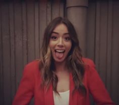 a woman in a red jacket making a funny face