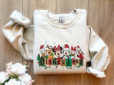 Retro Mickey and Friends Christmas Sweatshirt, Vintage Disneyland Christmas Sweatshirt, Disneyland Sweatshirt, Christmas Family Matching Welcome to Bee Design Gifts If you are looking for soft, comfy, first-rate sweatshirts, you're in the right place! I love what I do and strive to make your shopping experience just right for you. If you have any questions, concerns or comments about my products, feel free to send a message anytime. ⭐ 50% cotton, 50% polyester ⭐ Pre-shrunk ⭐Classic fit ⭐ 1x1 athletic rib knit collar with spandex ⭐ Air-jet spun yarn with a soft feel and reduced pilling ⭐Double-needle stitched collar, shoulders, armholes, cuffs, and hem HOW TO PLACE ORDER 1. Check photos for size chart, model comparison and color options 2. Select size and color from the drop down options 3. Disney Christmas Cardigan, Disneyland Christmas Sweater, Disney Shirt Christmas, Disneyland Outfits December, Family Disney Shirts Christmas, Christmas Disney Outfits, Disneyland Christmas Outfit, Mickey And Friends Christmas, Disneyland Sweatshirt