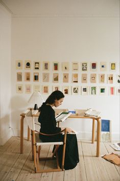 a woman sitting at a desk reading a book