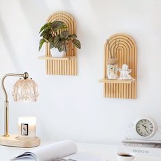 a white desk topped with two shelves filled with books and a lamp next to a cup of coffee