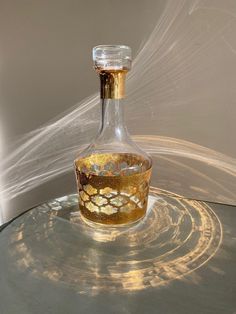 a glass bottle sitting on top of a table covered in gold flecks and water