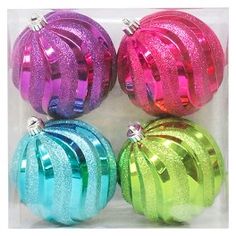 four shiny colored ornaments in a clear box