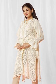 Ivory kurta with ecru floral lace base and scalloped lace bodice. 
Components: 1
Type Of Work: Lace
Neckline: Tie-up
Sleeve Type: Bell
Fabric: Lace
Color: Ivory
Other Details: 
Closure: Kurta: Front drawcord
Note: Churidar worn by the model is not for sale
Occasion: Puja,Mehendi and Haldi - Aza Fashions Lace Kurta, Kurta For Women, Lace Neckline, Fashion App, Churidar, Lace Bodice, Scalloped Lace, Color Ivory, Aza Fashion