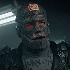 a man wearing a helmet with red eyes in the dark knight film, crae