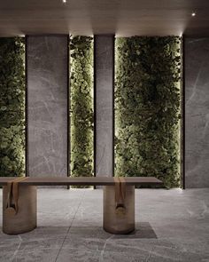 a bench sitting in front of two tall wall panels with moss growing on it's sides