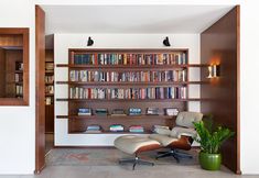 a living room filled with furniture and bookshelves next to a doorway that leads to another room