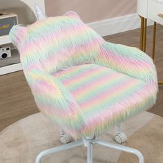 a pastel colored chair sitting on top of a wooden floor next to a white desk