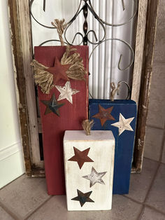 three wooden blocks with stars on them sitting in front of a door and a window