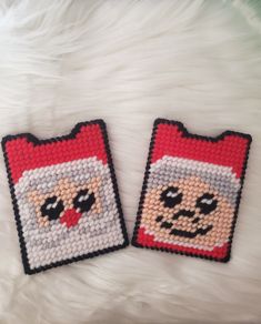 two cross stitch coasters with faces on them