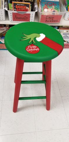 a green and red stool with an elf's hat on it in a store