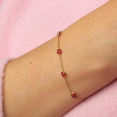 Our 14K Gold Evil Eye Bracelet is a blend of style and symbolism, inspired by the cultural heritage of the Turkish evil eye. This dainty bracelet, available exclusively in gold, features a choice of a blue or red evil eye charm, each known for its protective properties and cultural significance. The bracelet's delicate cable chain, with a thickness of 0.85 mm, is perfect for a subtle yet fashionable look and ideal for layering with other pieces. The adjustable length, ranging from 6.3" to 7.5", ensures a comfortable and versatile fit for various wrist sizes. Key Features: Cultural Symbol: Features a blue or red Turkish evil eye charm, known for its protective qualities and cultural significance. Delicate Design: Crafted with a slender cable chain, perfect for layering and versatile styling Red 14k Gold Dainty Bracelet, Red Evil Eye Jewelry, Dainty Yellow Gold Bracelet With Evil Eye Detail, Dainty Yellow Gold Bracelet With Evil Eye, Gold Evil Eye Bracelet, Red Evil Eye, Turkish Evil Eye, Evil Eye Protection, Dainty Bracelet