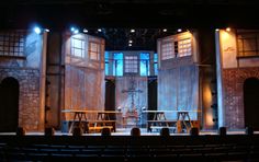 an empty stage with benches and tables in it