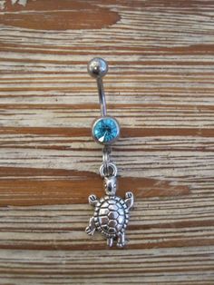 This super cute belly button ring that features a silver turtle charm that hangs from a standard 14 gauge surgical steel barbell with a light blue gem. It measures 3/4 inches long. Thanks for taking a look!   *If you would like this belly button ring in a different color gem or stone, just let me know. I would love to make it for you!* Silver Surgical Steel Belly Rings As Gift, Silver Dangle Belly Rings Nickel Free, Nickel-free Silver Dangle Belly Rings, Adjustable Nickel-free Stainless Steel Belly Rings, Adjustable Hypoallergenic Silver Belly Rings, Adjustable Silver Surgical Steel Belly Rings, Silver Hypoallergenic Dangle Belly Rings, Adjustable Nickel-free Sterling Silver Belly Ring, Hypoallergenic Silver Dangle Belly Rings