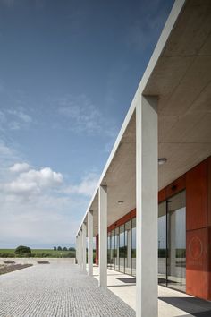 an empty walkway between two buildings with glass doors on each side and brick pavers flooring