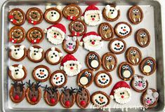 a tray filled with cookies decorated like santas and snowman's faces on top of each other