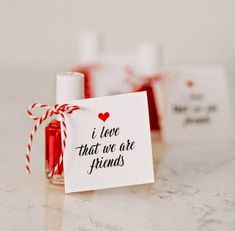 two small red and white gift bags tied with twine