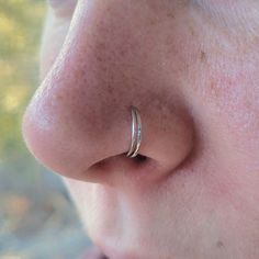 a close up of a person's nose with a ring on top of it