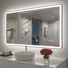 a bathroom vanity with a large mirror above it and a bowl of flowers on the counter