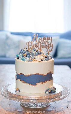 a birthday cake sitting on top of a table next to a blue couch and window