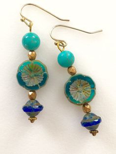 "Lightweight earrings handmade of semi-transparent aqua blue Czech glass Picasso flower, 8mm turquoise howlite, and cobalt blue Picasso UFO bead. Accented with light bronze Czech glass beads and gold wire. Earrings come on simple gold plated fish hook ear wires, lead and nickel free. Measure 2 1/8\"'long from top of ear wire." Nickel Free Czech Glass Flower Earrings, Turquoise Glass Drop Earrings, Turquoise Czech Glass Round Beads Jewelry, Turquoise Czech Glass Bead Jewelry, Blue Flower-shaped Jewelry With Spacer Beads, Turquoise Nickel-free Flower Earrings For Jewelry Making, Turquoise Czech Glass Beaded Earrings, Blue Round Beaded Earrings With Spacer Beads, Bohemian Blue Nickel-free Flower Earrings