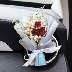 a bouquet of flowers sitting on the dashboard of a car