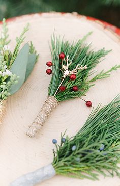 two flowers are sitting on top of a piece of wood next to a pair of scissors