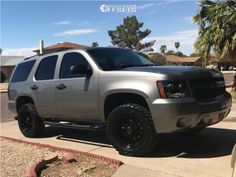 a silver truck parked on the side of a road in front of a palm tree